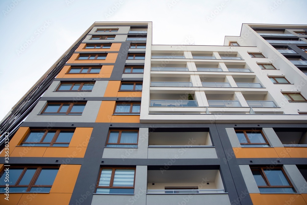 Exterior of new apartment buildings on a blue cloudy sky background. No people. Real estate business concept. Exterior of new apartment buildings on a blue cloudy sky background. No people. Real estate business concept.