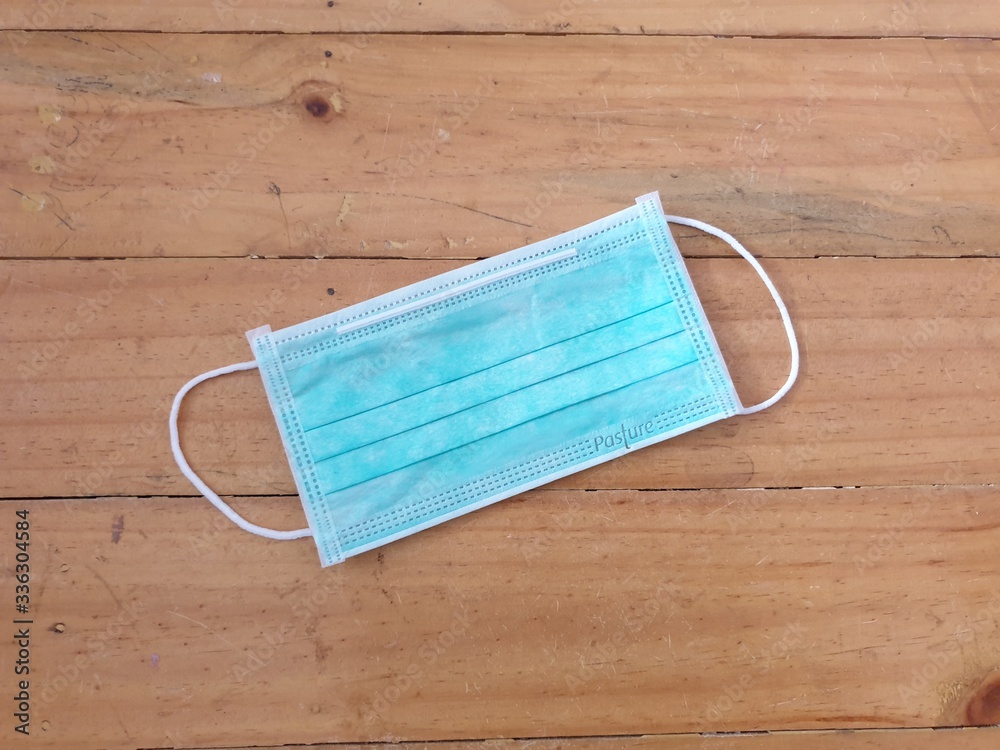 blank paper on wooden background.Surgical mask on wooden background.
blank paper on wooden background.Surgical mask on wooden background.