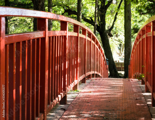 Red bridge across the Togawa river leading to Manji Stone Buddha in Shimosuwa - Nagano prefecture, Japan photo