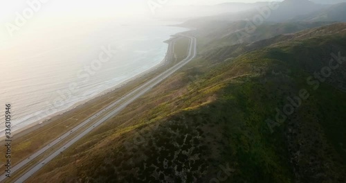 Aerial view Ascending shot, Cars moving along Highway One, Shoreline and Cross Canyon in the background. photo