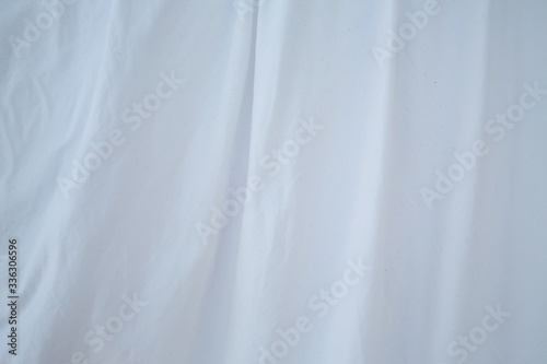Blurred white bedsheet drying in the sun, Wrinkled texture, Abstract background, Close up shot, Selective focus, Housework, Laundry concept