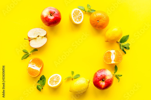 Fototapeta Naklejka Na Ścianę i Meble -  Colorful fruit mockup. Cut apple, kiwi, citrus on yellow background top-down copy space