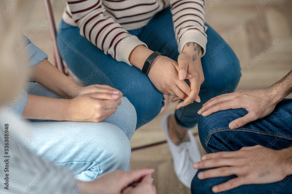 Group of people sitting in a circle close to each other Group of people sitting in a circle close to each other