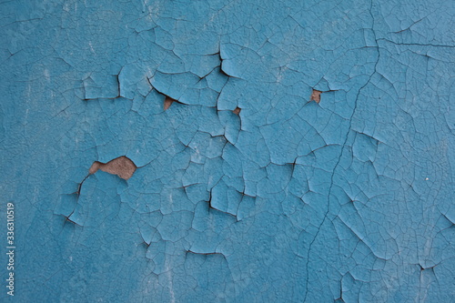 blue paint on the wall. gray concrete wall painted. old paint is peeling and peeling off.
 photo
