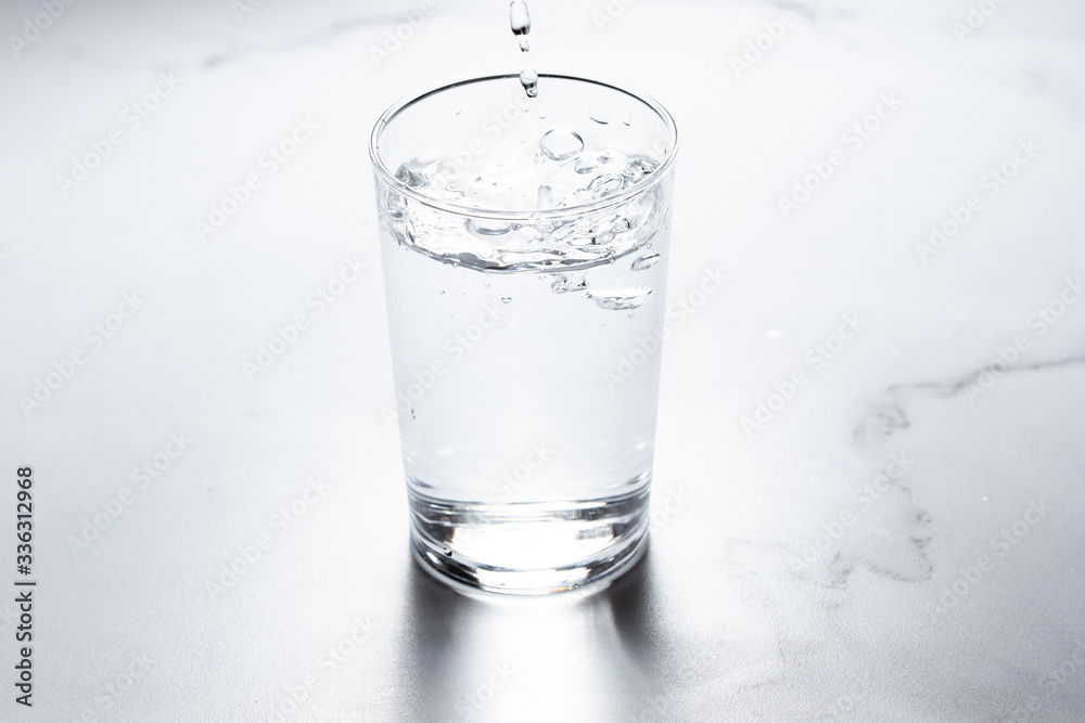 水をグラスに注ぐ。水分補給。健康・スポーツやトレーニング。 水をグラスに注ぐ。水分補給。健康・スポーツやトレーニング。