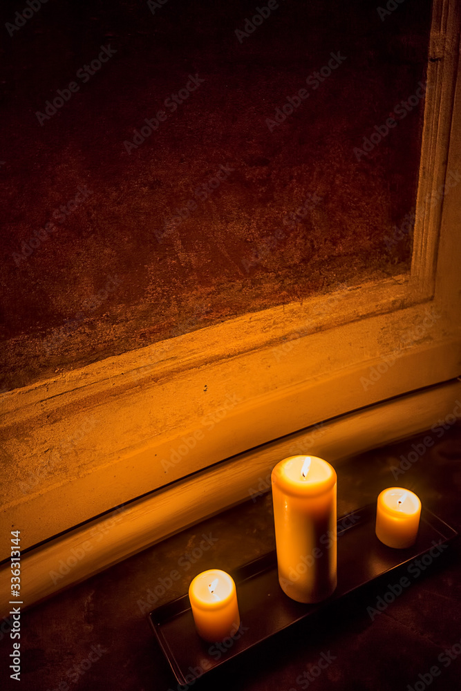 Φωτογραφία Wide angle view of the corner of a room lit only by the warm glow of three candl