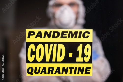 Man in protective white overalls, mask and glasses on his face. Coronavirus, pandemic, covid-19, flu and quarantine concept.