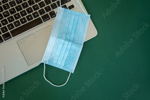 Medical breathing mask on laptop for online work from home