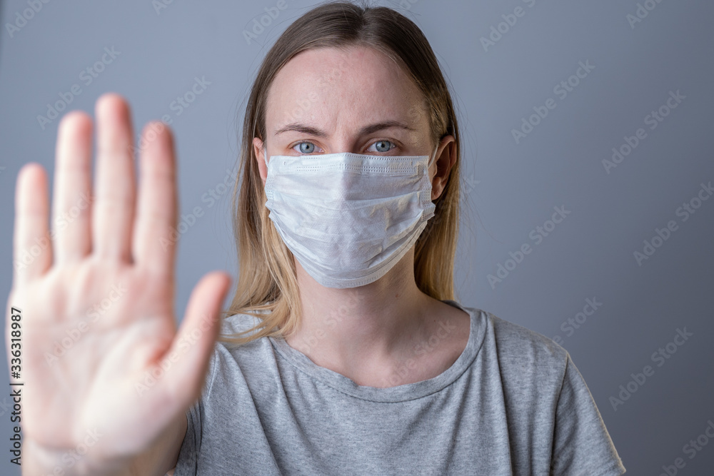 Help stop spreading globally corona virus pandemic infectious disease outbreak. On background woman in mask focus on stretched hand as symbol of keep distance avoid communication, healthcare concept Help stop spreading globally corona virus pandemic infectious disease outbreak. On background woman in mask focus on stretched hand as symbol of keep distance avoid communication, healthcare concept