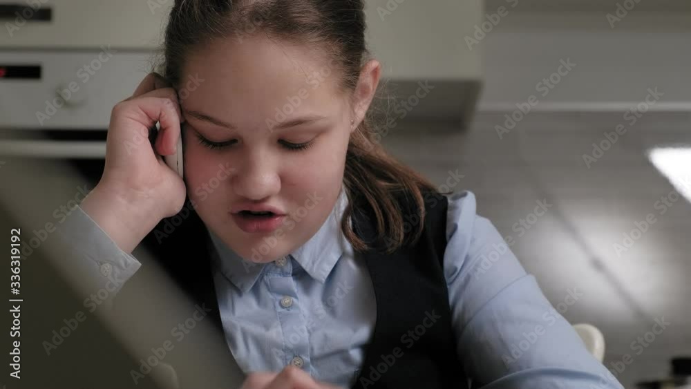 Teenage girl in a school uniform does homework Teenage girl in a school uniform does homework
