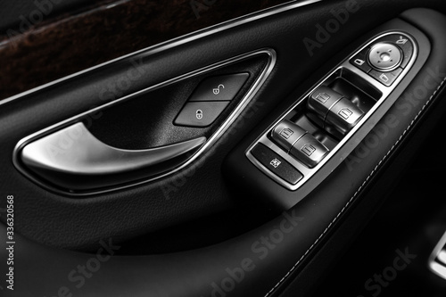 Closeup of a door control panel in a new car. Arm rest with window control panel, door lock, seat adjustment   buttons, and mirror control © Виталий Сова