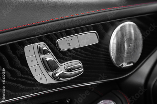 Closeup of a door control panel in a new car. Arm rest with window control panel, door lock, seat adjustment   buttons, and mirror control © Виталий Сова