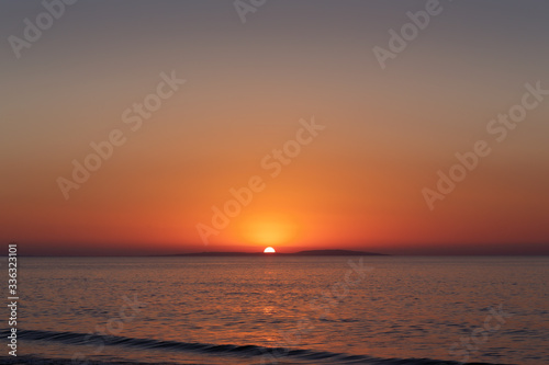Sea coast at sunset  with the sun  wave  orange sky