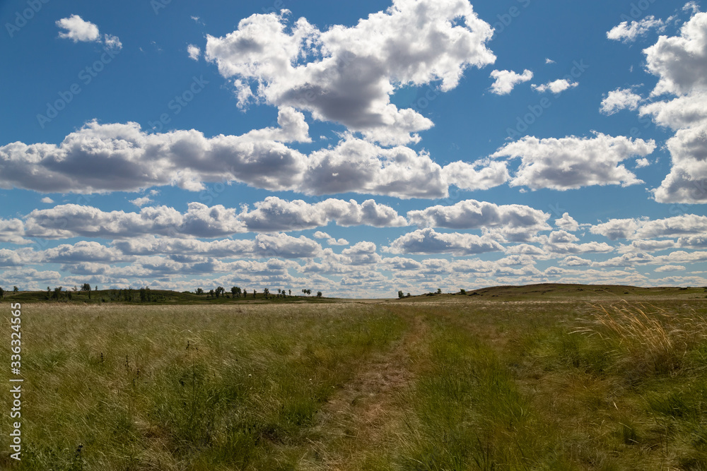 road to the field and blue sky with clouds
