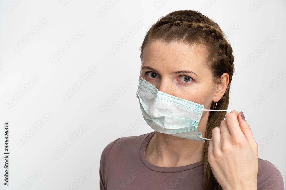 adult woman puts a protective mask on her mouth to protect herself from viral diseases and bacteria. surgical mask protects against coronavirus