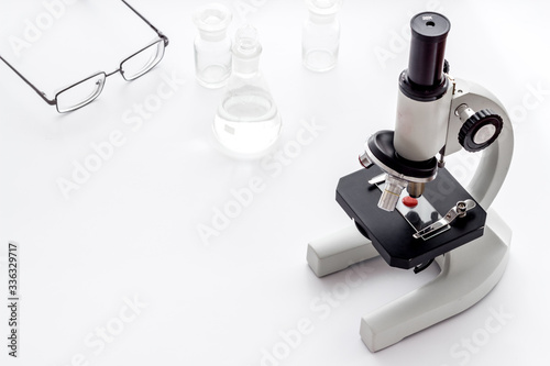 Laboratory examination with microscope. Equipment with blood sample on white background copy space