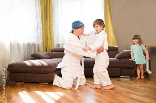 Dad and son in white kimono judo training at home. quarantine. health concept. Corona Virus. standing in home. chelter in place. home workouts 