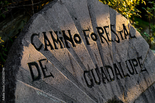 Round stone like a wheel with the name of the hiking route Camino Forestal de Guadalupe. Basque Country, Spain.