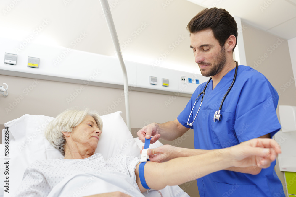 Fototapeta premium a doctor takes blood from a female senior