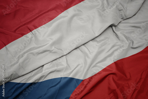 waving colorful flag of czech republic and national flag of indonesia.