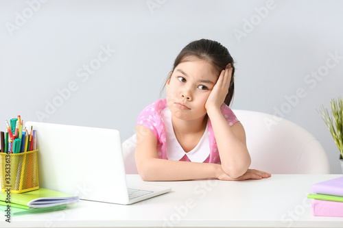 Bored little Asian girl doi...