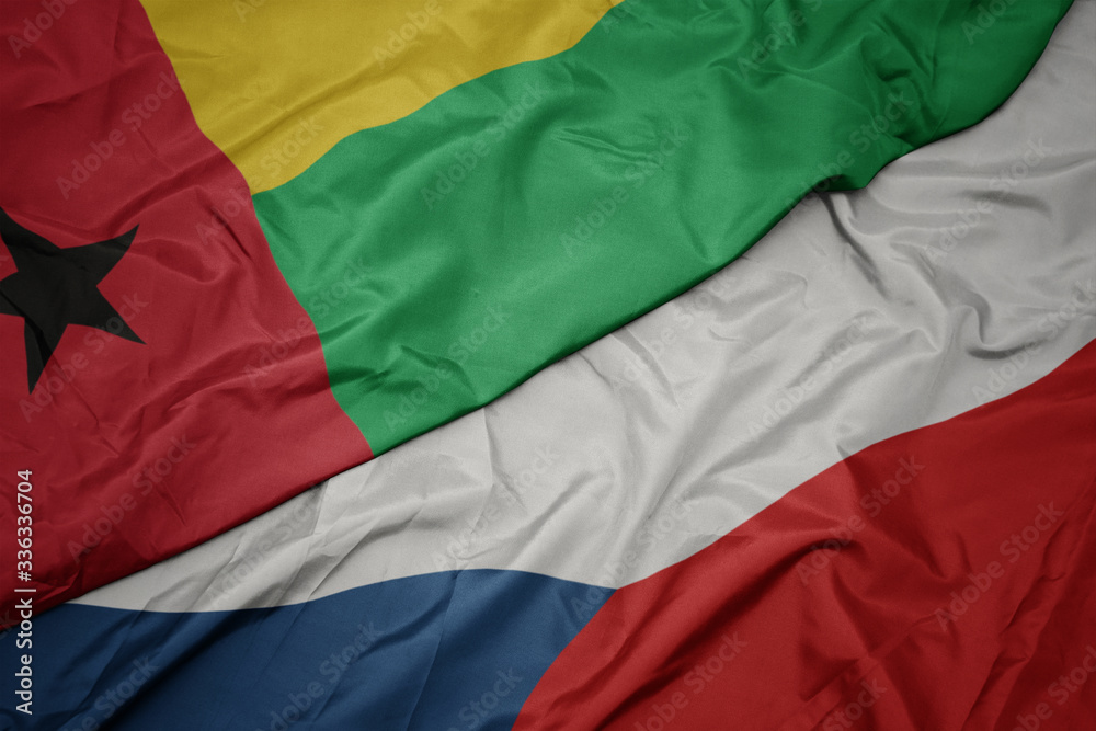 waving colorful flag of czech republic and national flag of guinea bissau.