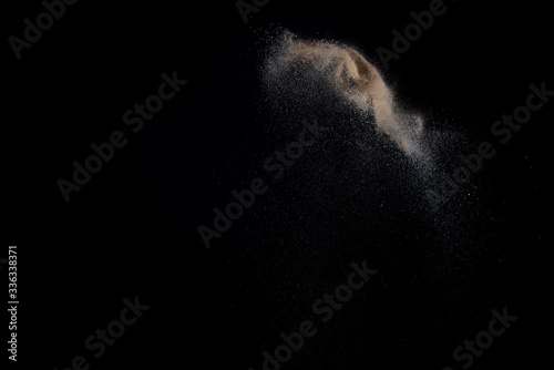 Sandy explosion isolated on black background. Abstract particles cloud. Texture element for design.
