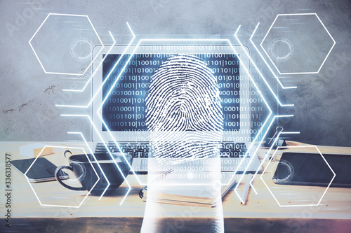 Computer on desktop in office with finger print drawing. Double exposure. Concept of business data security.