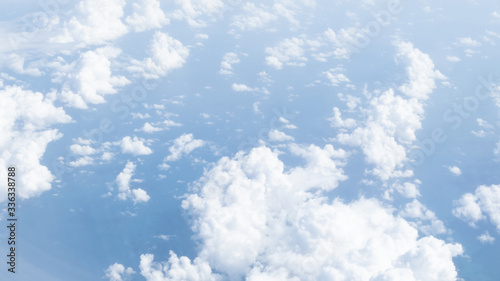 Blue sky and white clouds view looking through airplane window. Travel, vacation and journey concept.Soft focus, Select focus. Panorama image.