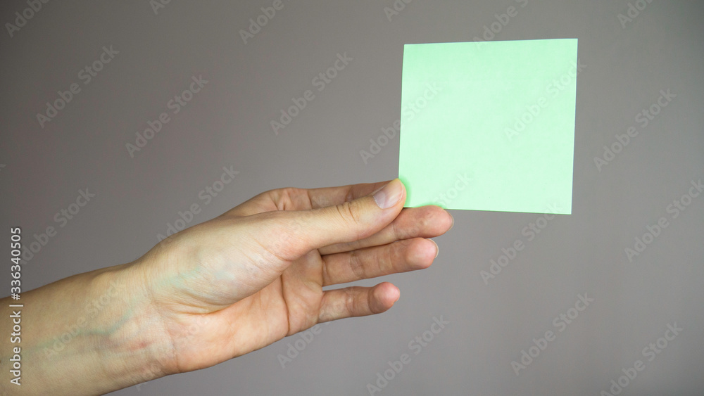 Fototapeta premium Square paper with space for text in the hand. 