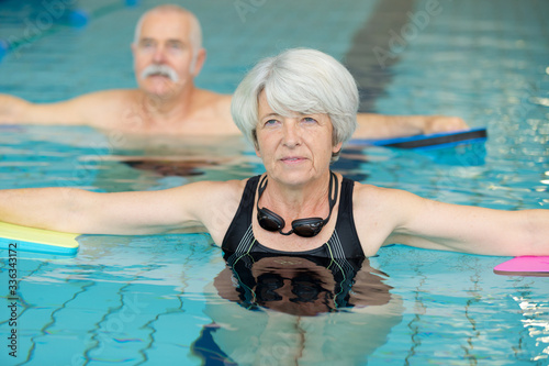 senior couple participating in aquatic exercise class © auremar