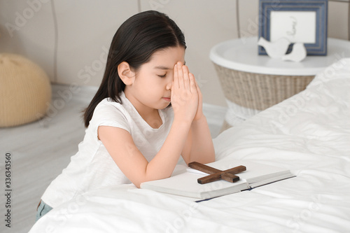 Cute little Asian girl pray...