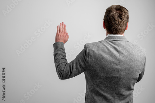 Back view of business man wearing business clothes taking oath