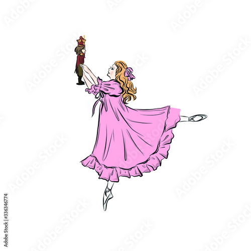 Little ballerina in pink ball gown dancing in pointe shoes holding nutcracker toy. Princess girl. 