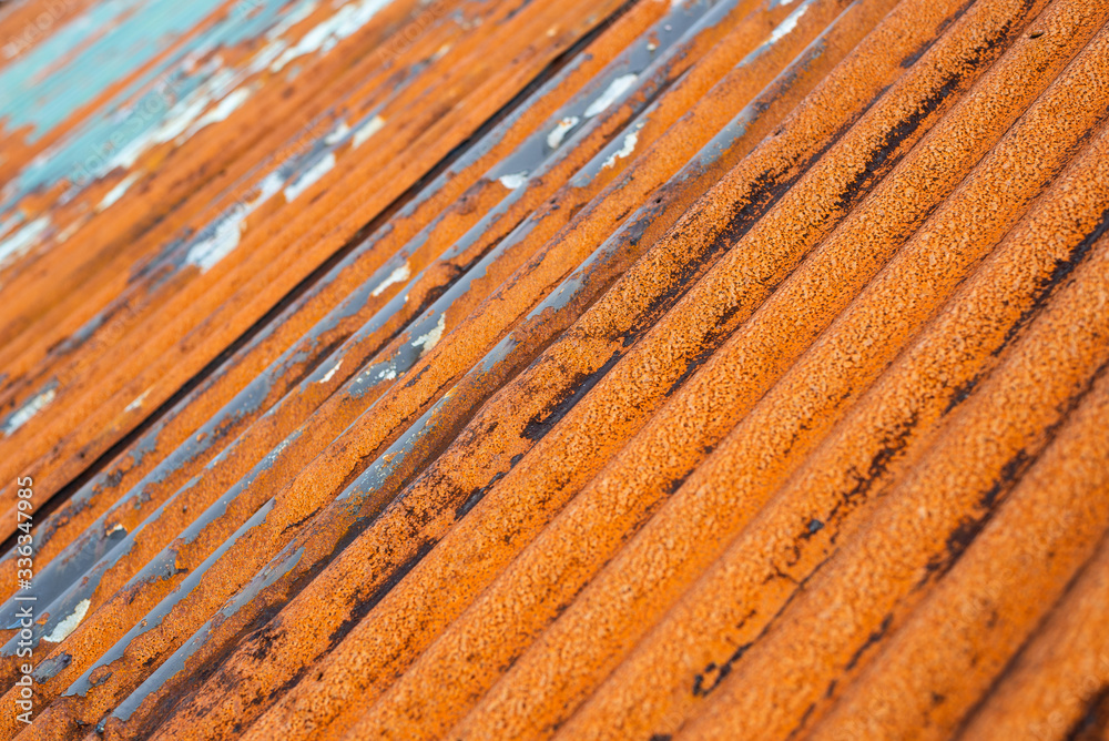 Closeup of rusty metal roof with damaged elements and peeled off paint Closeup of rusty metal roof with damaged elements and peeled off paint