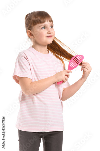 Little girl brushing hair o...