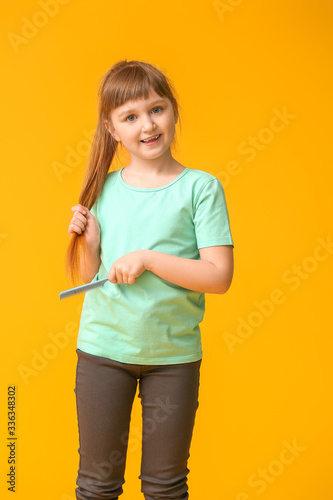 Little girl combing hair on...
