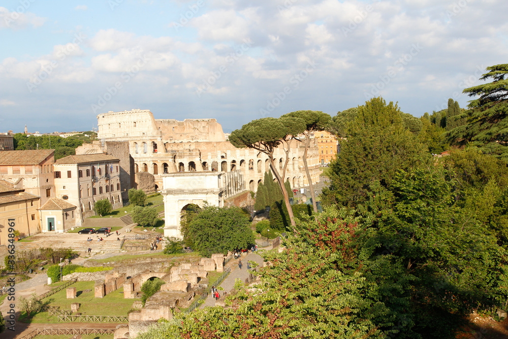 Aerial panoramic cityscape view of the Roman Forum and Roman Colosseum during sunset in Rome, Italy