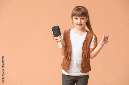 Little girl with hair brush...