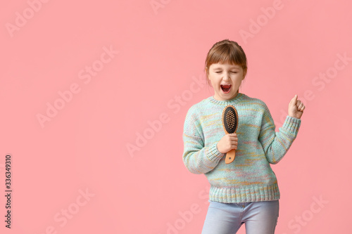 Little girl using hair brus...
