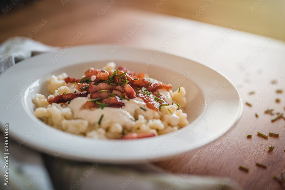 Bryndz gnocchi in white plates on wooden table.