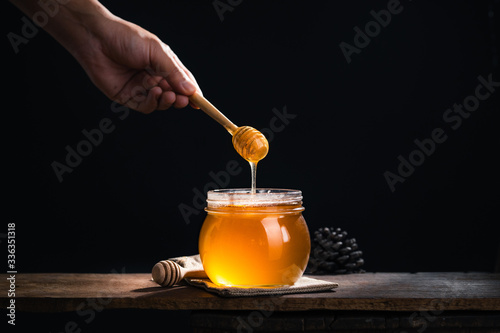 Honey in a glass jar,Scoop the honey in a glass jar photo