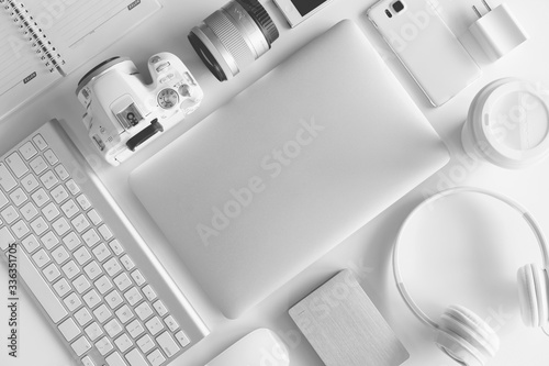Flat lay of white office desk table with many white gadgets photo
