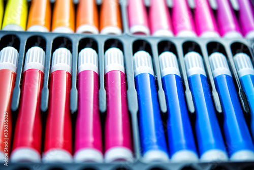 Soft focus close-up of palette of colored markers in box with plastic insert. Colored drawing markers in a variety of colors. Close-up. Tools for painting on quarantine time. Defocused