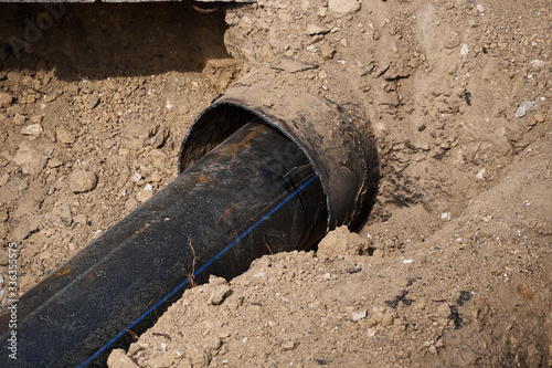 repair and replacement main pipeline of heating systems, district heating pipes network, water supply or Sewerage in city, removing old pipes and replacing them with new ones in a hole in the ground photo