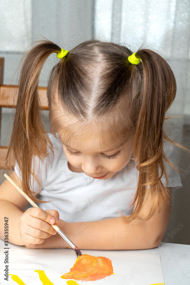 what to do to the child during the period of quarantine and self-isolation, the girl plays and draws. sitting on a chair at the table and bowed her head what to do to the child during the period of quarantine and self-isolation, the girl plays and draws. sitting on a chair at the table and bowed her head