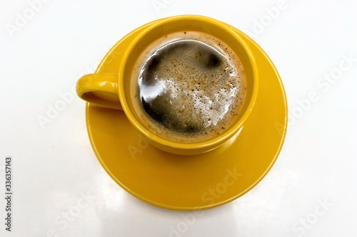 Yellow cup of hot coffee on white background © Алена Ваторина