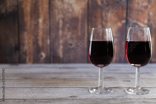  two red wine glasses on wooden