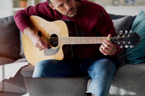 Photos Man playing acoustic guitar at home