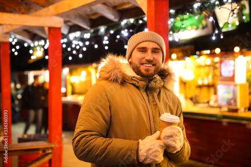 Happy man with drink at Christmas fair